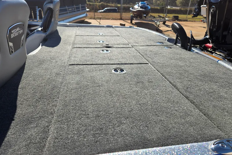 Slide: The Image of 2025 Skeeter FXR20 PRO boat deck with carpeted surface and storage compartments. - 11