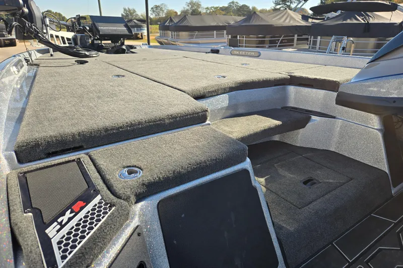 Slide: The Image of 2025 Skeeter FXR20 PRO boat deck with carpeted surface and storage compartments. - 13