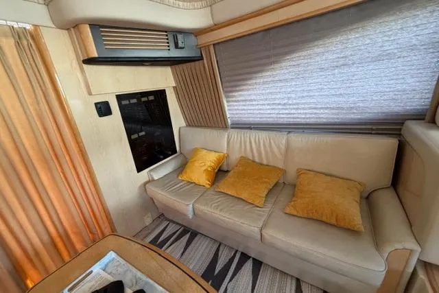 Slide: The Image of Interior of 2004 Sea Ray 420 Sedan Bridge with beige sofa and yellow cushions. - 14
