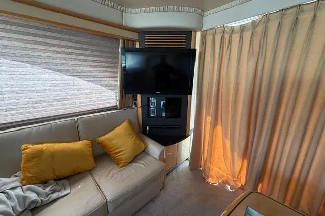 Slide: The Image of Interior of 2004 Sea Ray 420 Sedan Bridge with TV, sofa, and curtains. - 15