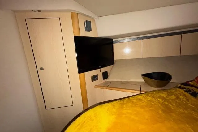 Slide: The Image of Interior of 2004 Sea Ray 420 Sedan Bridge with TV and modern cabinetry. - 18