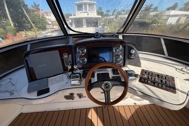 Slide: The Image of 2004 Sea Ray 420 Sedan Bridge helm with wooden steering wheel and navigation controls. - 4