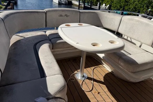 Slide: The Image of 2004 Sea Ray 420 Sedan Bridge boat with cushioned seating and table on deck. - 7