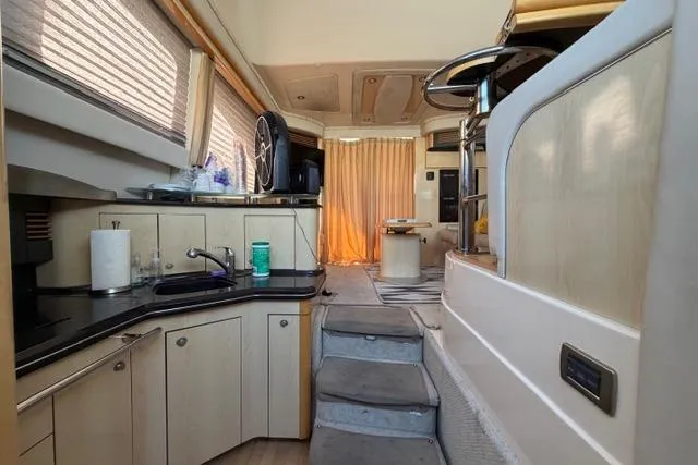Slide: The Image of Interior of 2004 Sea Ray 420 Sedan Bridge yacht with modern kitchen and seating area. - 9
