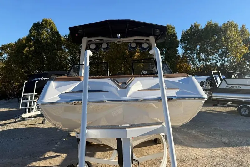 Slide: The Image of 2026 Tigé 22RZX boat displayed outdoors with trees in the background. - 2