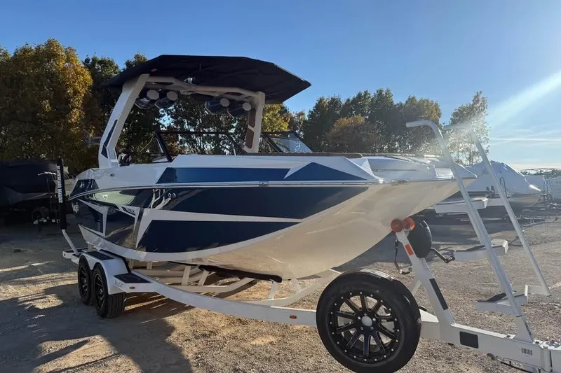 Slide: The Image of 2026 Tigé 22RZX boat on trailer, parked outdoors under clear sky. - 3