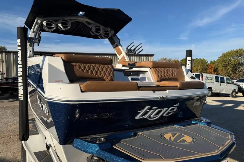 Slide: The Image of 2026 Tigé 22RZX boat with luxurious seating and sleek design in a marina setting. - 5
