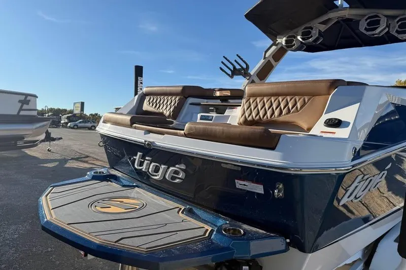 Slide: The Image of 2026 Tigé 22RZX boat with brown seating and sleek design in a sunny outdoor setting. - 6