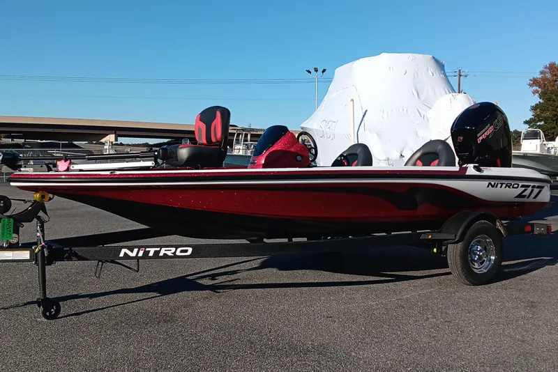 Slide: The Image of 2026 Nitro Z17 boat on trailer, red and black design, parked outdoors. - 2