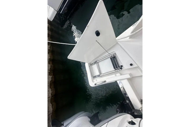 Slide: The Image of 2023 Tiara Yachts 34 LS swim platform with ladder, docked by water. - 11
