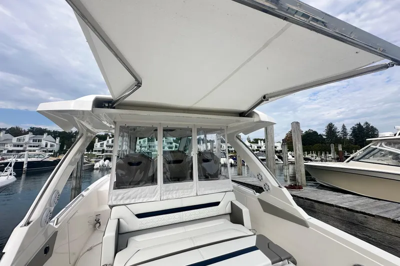 Slide: The Image of 2023 Tiara Yachts 34 LS at marina, featuring spacious seating and canopy. - 13