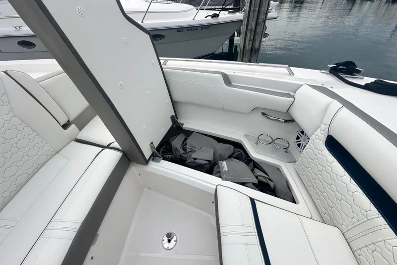 Slide: The Image of 2023 Tiara Yachts 34 LS boat interior with open storage compartment and luxurious seating. - 16