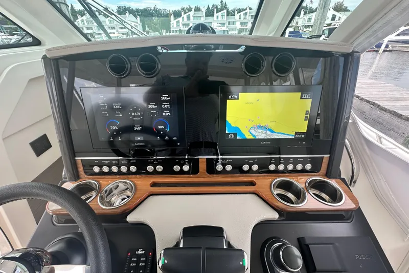 Slide: The Image of 2023 Tiara Yachts 34 LS dashboard with dual Garmin displays and navigation controls. - 19