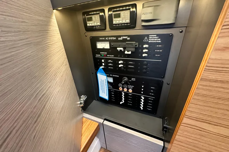 Slide: The Image of Electrical control panel inside 2023 Tiara Yachts 34 LS, featuring AC and DC systems. - 29