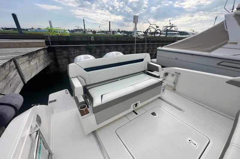 Slide: The Image of 2023 Tiara Yachts 34 LS boat interior with seating and storage at a marina. - 8