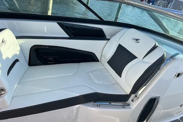Slide: The Image of 2017 Monterey 328SS Super Sport boat interior with white and black seating by the water. - 15