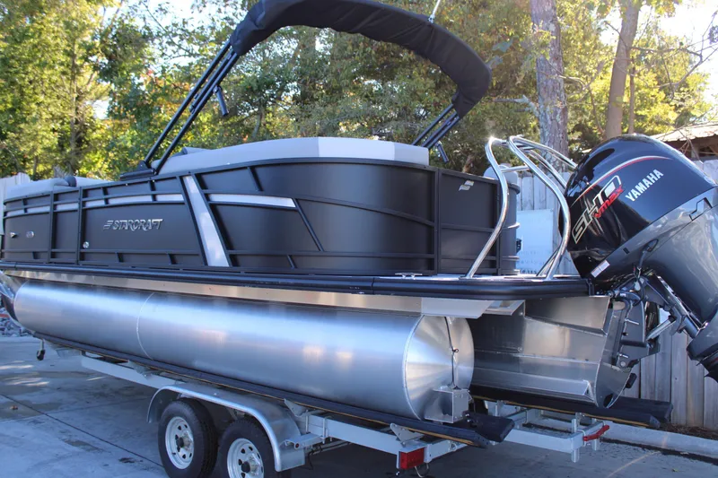 Slide: The Image of 2026 Starcraft EXS 3 pontoon boat on trailer with Yamaha engine, surrounded by trees. - 4