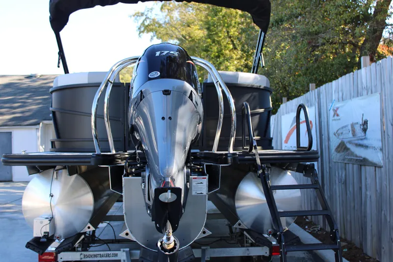 Slide: The Image of 2026 Starcraft EXS 3 pontoon boat with powerful outboard motor, parked outdoors. - 6