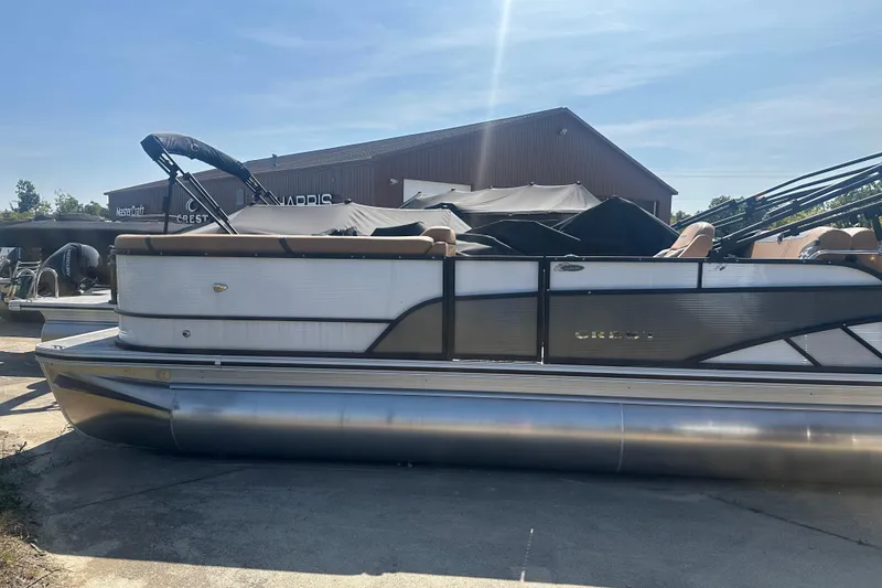 The Image of 2025 Crest Classic 240 pontoon boat parked outdoors on a sunny day. - 1