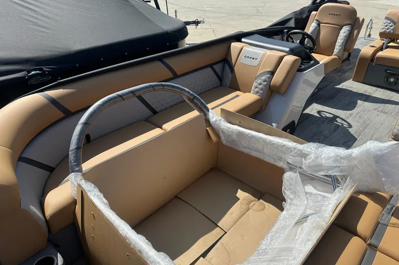 Slide: The Image of 2025 Crest Classic 240 boat interior with tan seating and steering console. - 5