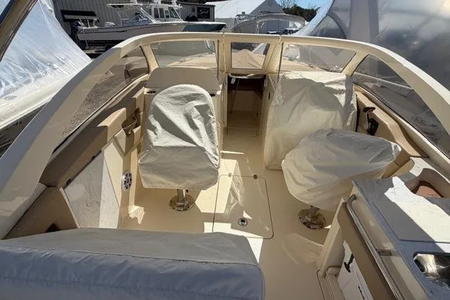 Slide: The Image of 2021 Scout 235 Dorado boat interior with covered seats and steering area. - 12