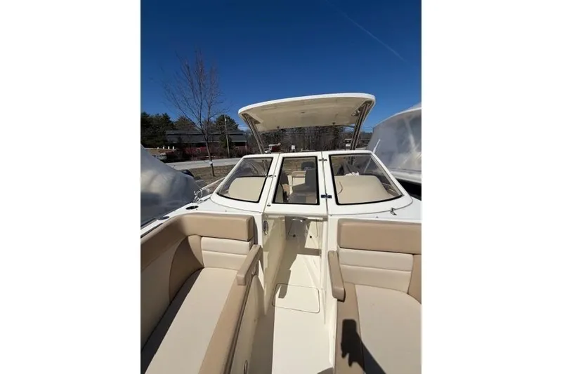 Slide: The Image of 2021 Scout 235 Dorado boat interior with beige seating under clear blue sky. - 4