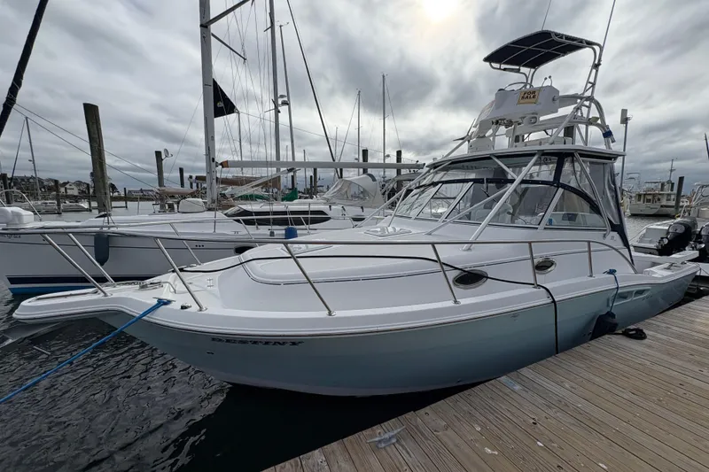 The Image of 2005 Pro-Line 33 Express boat docked at marina under cloudy sky. - 0
