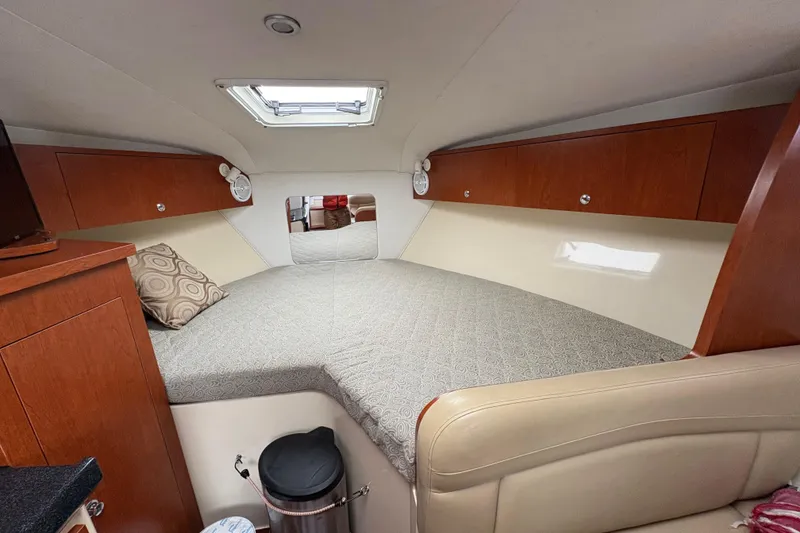Slide: The Image of 2005 Pro-Line 33 Express cabin interior with bed, wooden cabinets, and skylight. - 19