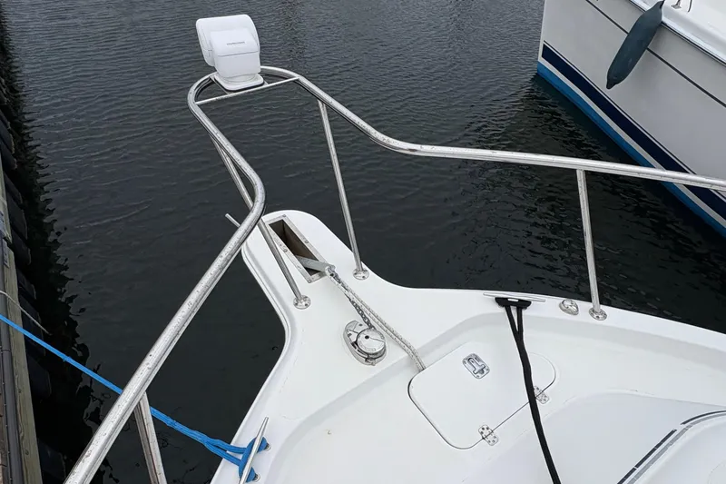 Slide: The Image of 2005 Pro-Line 33 Express boat bow with railing and anchor at dock. - 29