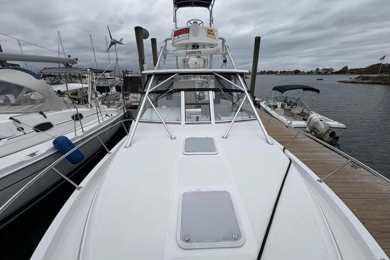 Slide: The Image of 2005 Pro-Line 33 Express boat docked, featuring a sleek white deck and marina backdrop. - 30