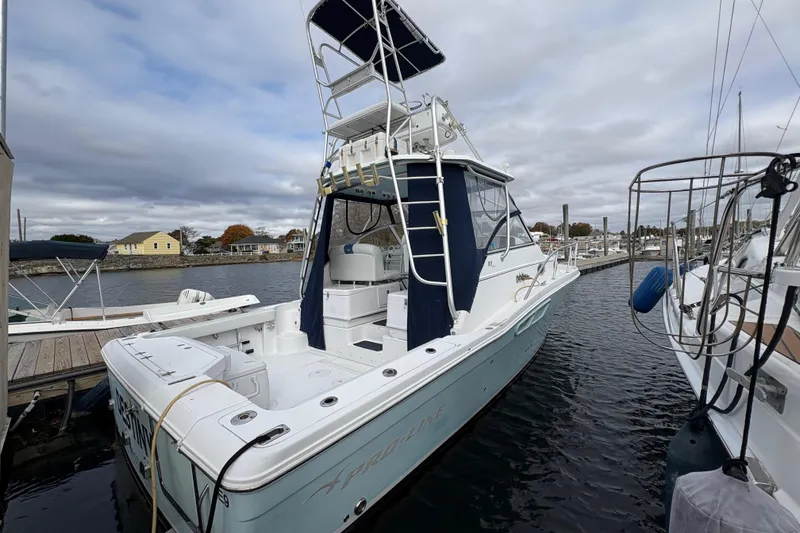 Slide: The Image of 2005 Pro-Line 33 Express boat docked at marina under cloudy sky. - 7