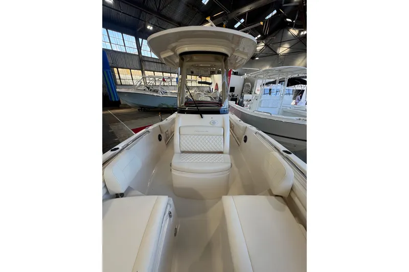 Slide: The Image of 2025 Grady-White Fisherman 216 boat interior with cushioned seating in a showroom. - 10