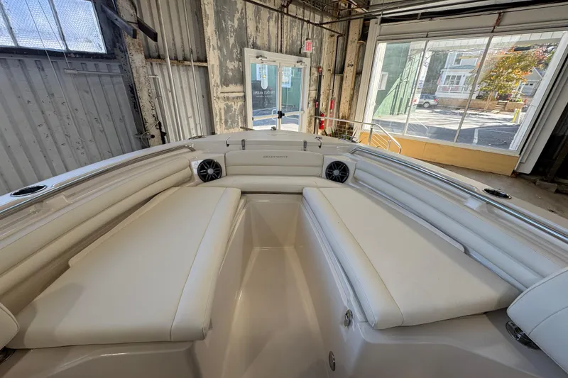 Slide: The Image of 2025 Grady-White Fisherman 216 boat interior with cushioned seating in a warehouse. - 11