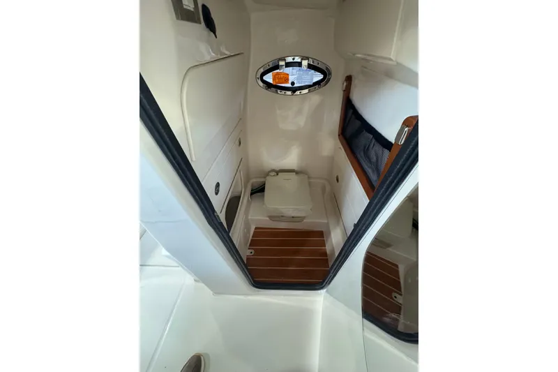 Slide: The Image of 2025 Grady-White Fisherman 216 boat interior with compact cabin and wooden flooring. - 8
