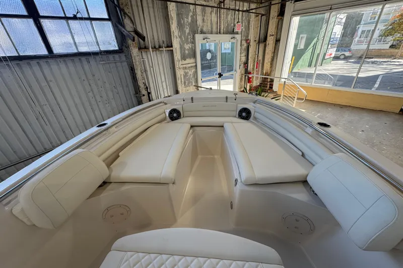 Slide: The Image of 2025 Grady-White Fisherman 216 boat interior with white seating in a warehouse setting. - 9