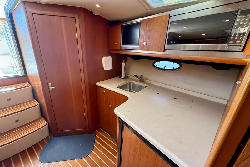 Slide: The Image of Luxurious 2005 Tiara 3600 Open yacht interior with kitchenette and cozy sleeping area. - 19