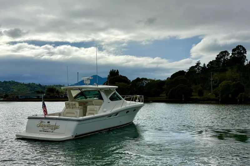 Slide: The Image of 2005 Tiara 3600 Open yacht on calm water, surrounded by lush greenery. - 2