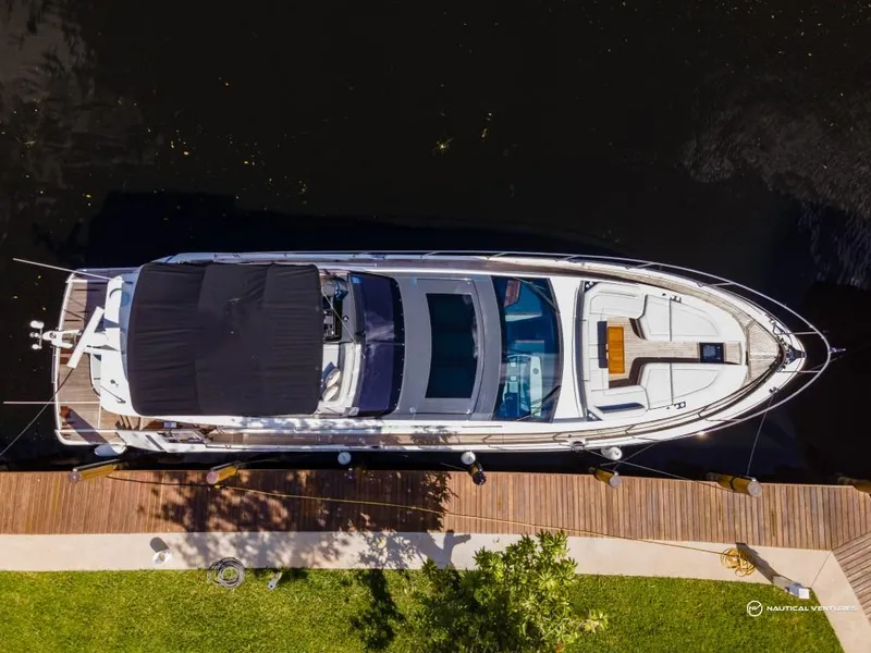 Slide: The Image of Aerial view of 2023 Fairline Phantom 65 yacht docked by a wooden pier. - 19
