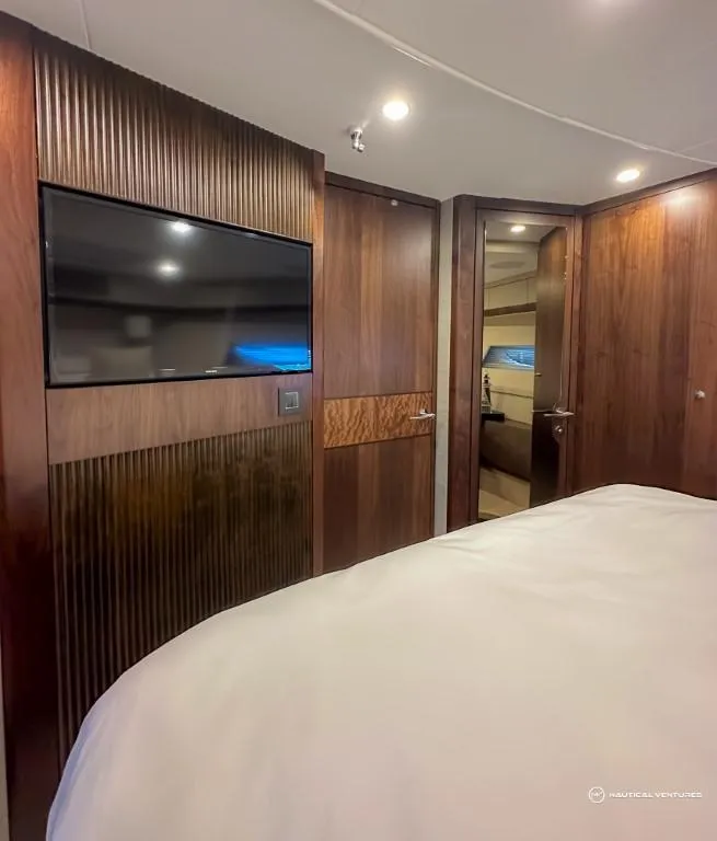 Slide: The Image of 2023 Fairline Phantom 65 yacht bedroom with TV and wooden interior. - 39