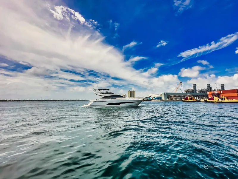 Slide: The Image of Fairline Phantom 65 yacht cruising near a harbor, 2023 model. - 8