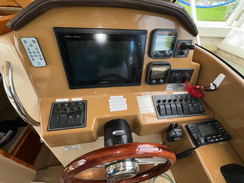 Slide: The Image of 2016 Cutwater C 24 Coupe helm with Garmin GPS, controls, and wooden steering wheel. - 12