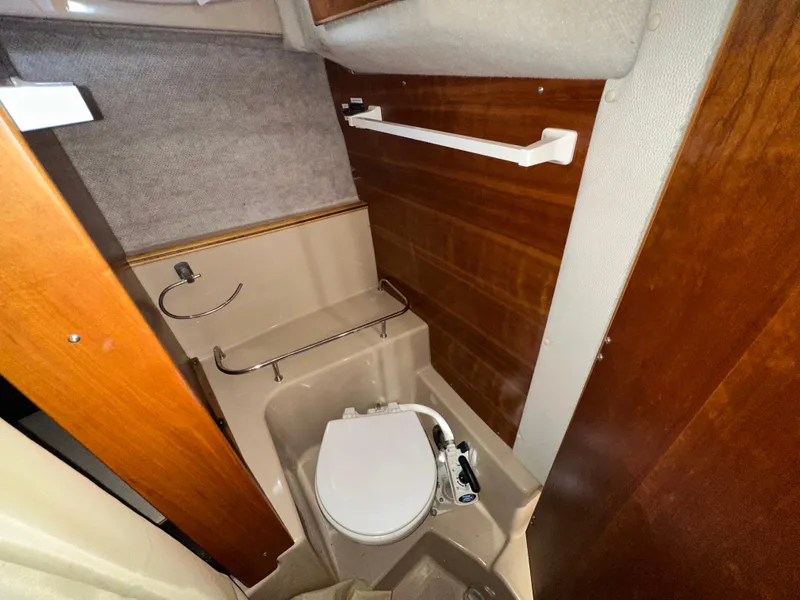 Slide: The Image of 2016 Cutwater C 24 Coupe boat bathroom with wooden accents and compact toilet. - 16
