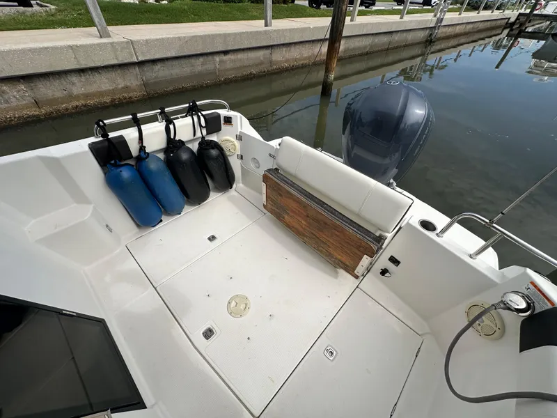 Slide: The Image of 2016 Cutwater C 24 Coupe boat interior with fenders and outboard motor at dock. - 5