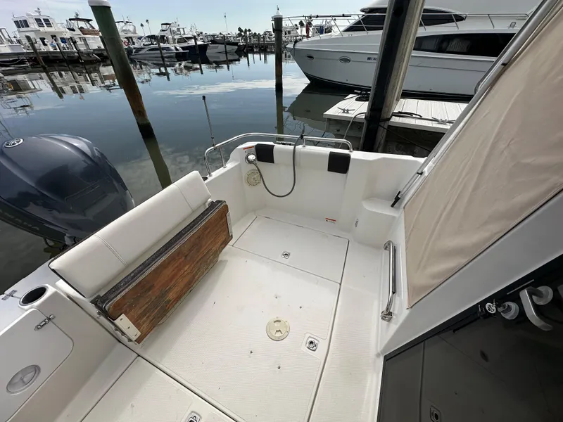 Slide: The Image of 2016 Cutwater C 24 Coupe boat interior at marina, featuring seating and docked vessels. - 6