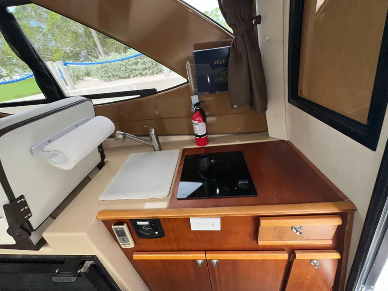 Slide: The Image of Compact kitchen area in a 2016 Cutwater C 24 Coupe boat, featuring a sink and stove. - 8