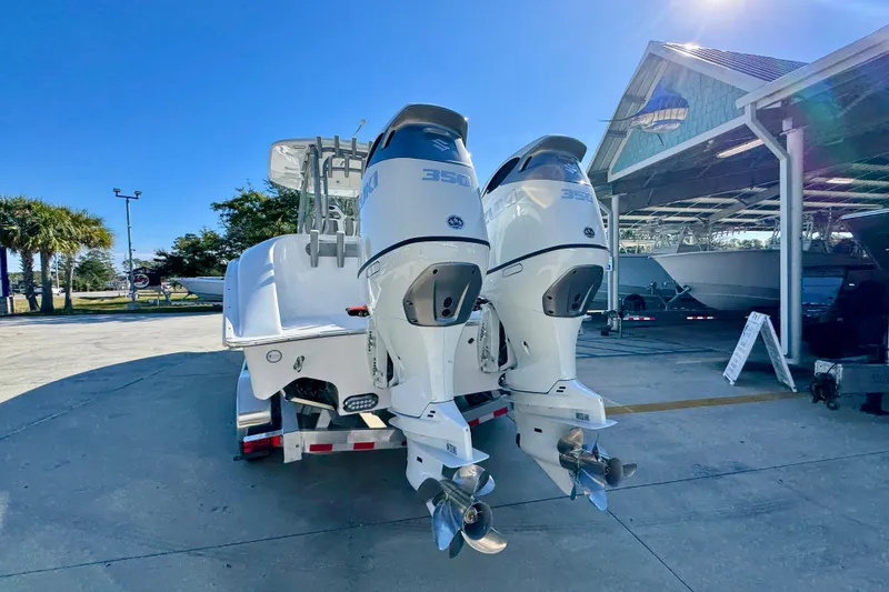 Slide: The Image of 2026 Cape Horn 32 XS boat with twin outboard engines in a sunny marina. - 16