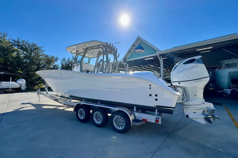 Slide: The Image of 2026 Cape Horn 32 XS boat with Suzuki engines on a trailer under clear blue sky. - 18