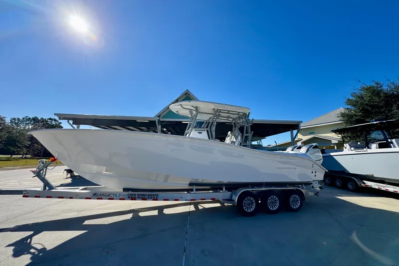 Slide: The Image of 2026 Cape Horn 32 XS boat on trailer under clear blue sky. - 2