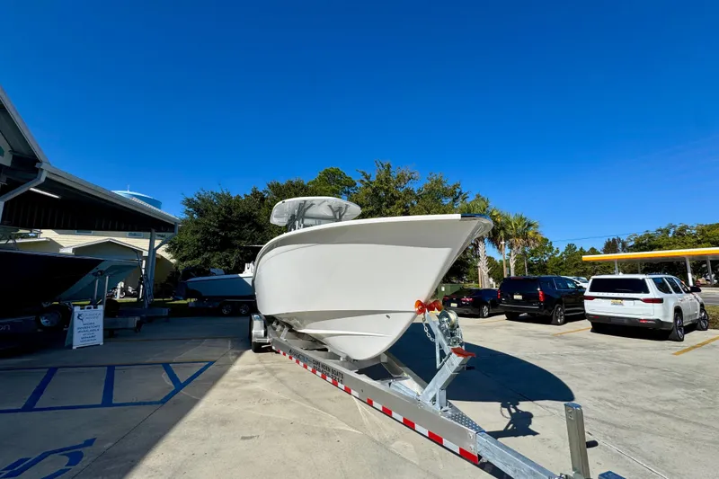 Slide: The Image of 2026 Cape Horn 32 XS boat on trailer in parking lot under clear blue sky. - 7