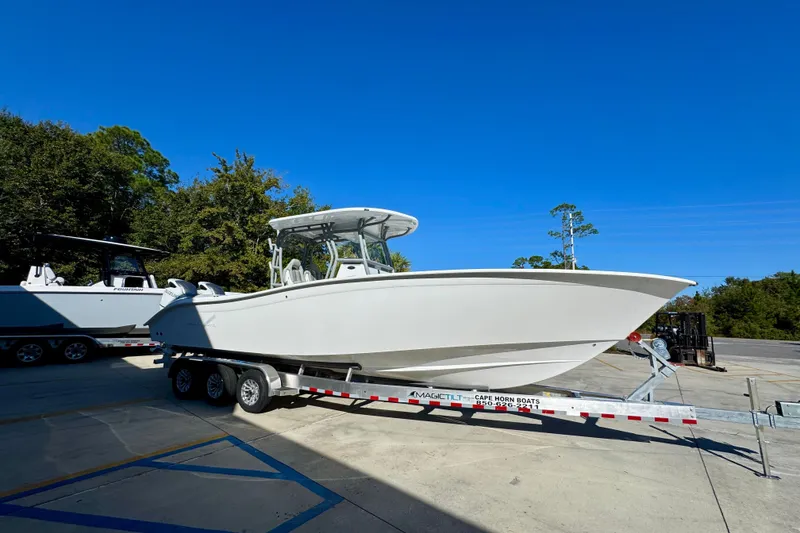 Slide: The Image of 2026 Cape Horn 32 XS boat on trailer, parked outdoors under clear blue sky. - 9